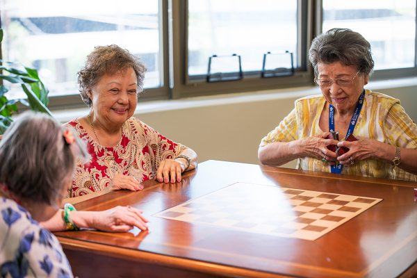 Women sitting around a chess board table