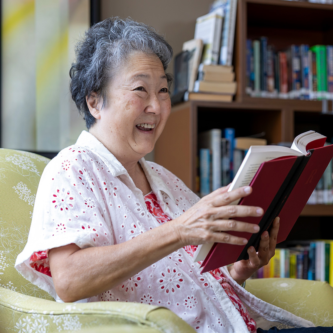 Woman smiling holding a book.